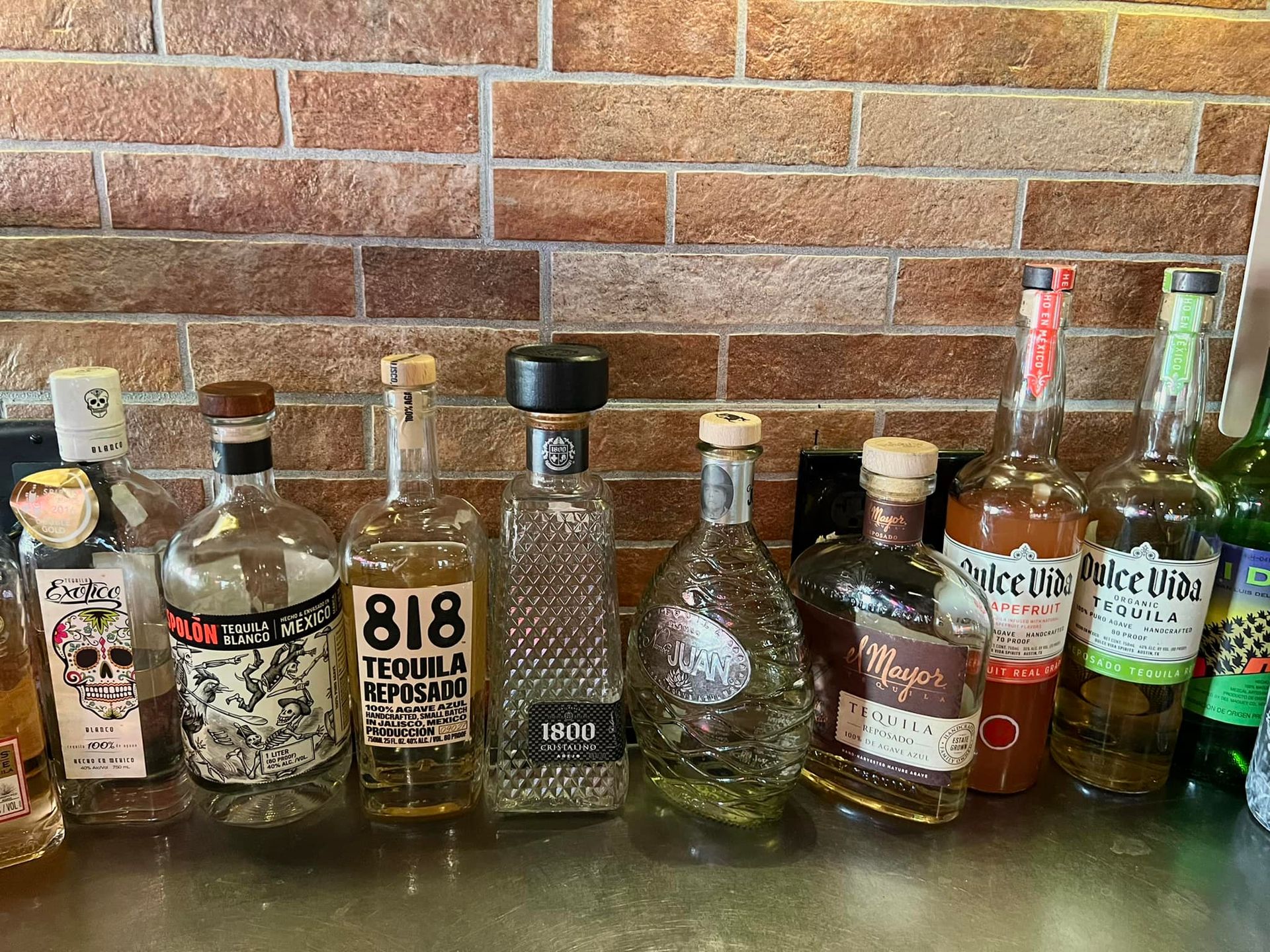 A row of bottles of alcohol are lined up on a counter.