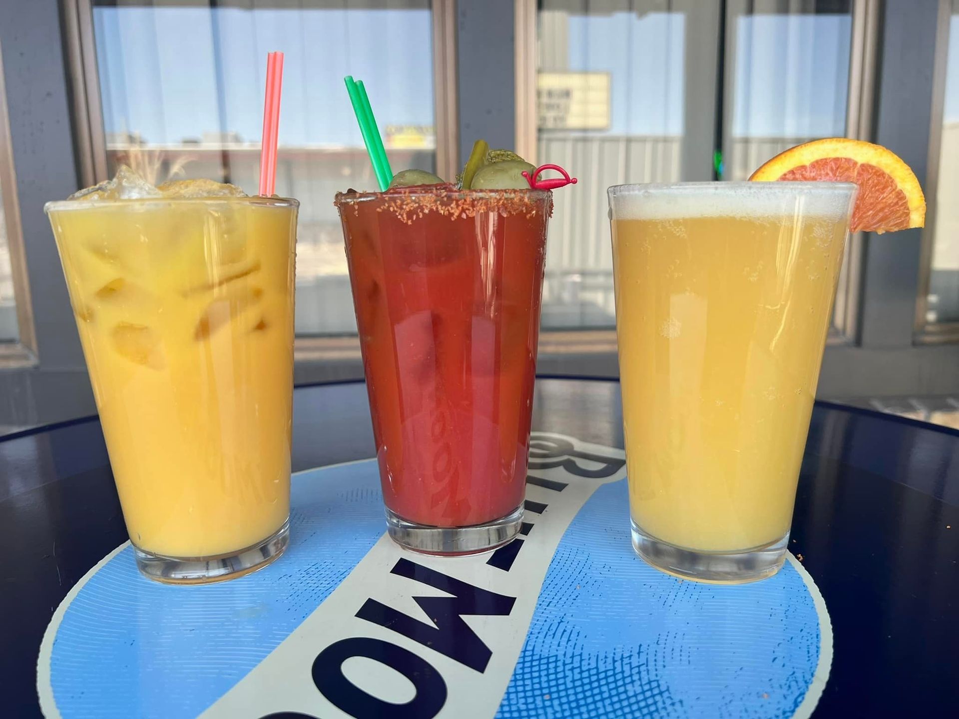 Three drinks are sitting on a table with a sign that says rum moon