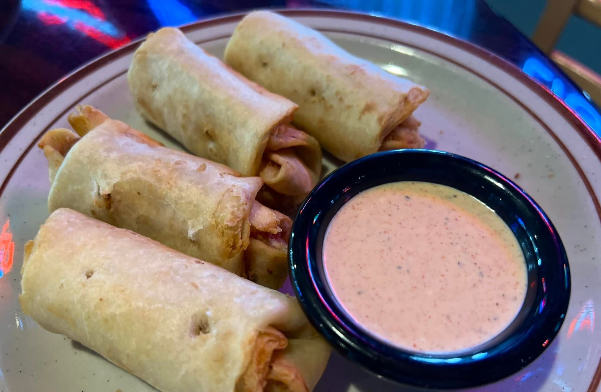A plate of food with a dipping sauce on it.