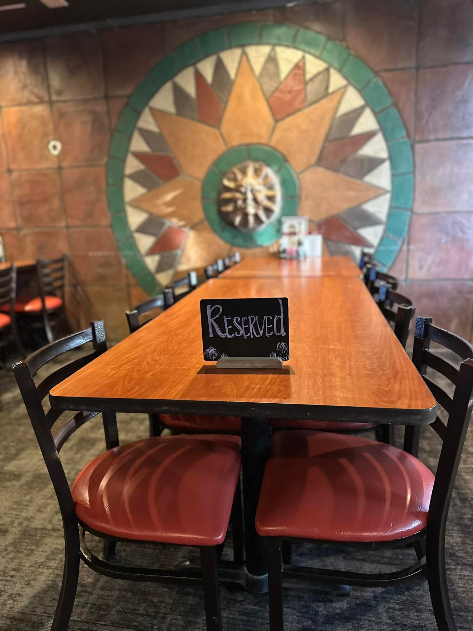 A long wooden table with a sign on it that says reserved