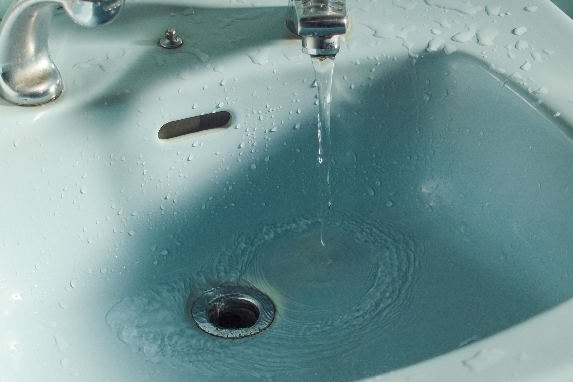 A bathroom sink with water coming out of the faucet.