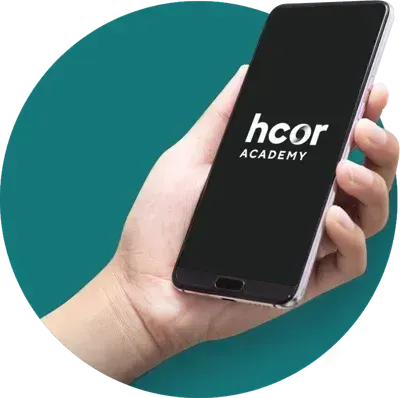 Uma pessoa está segurando um celular que diz hcor academy na tela.