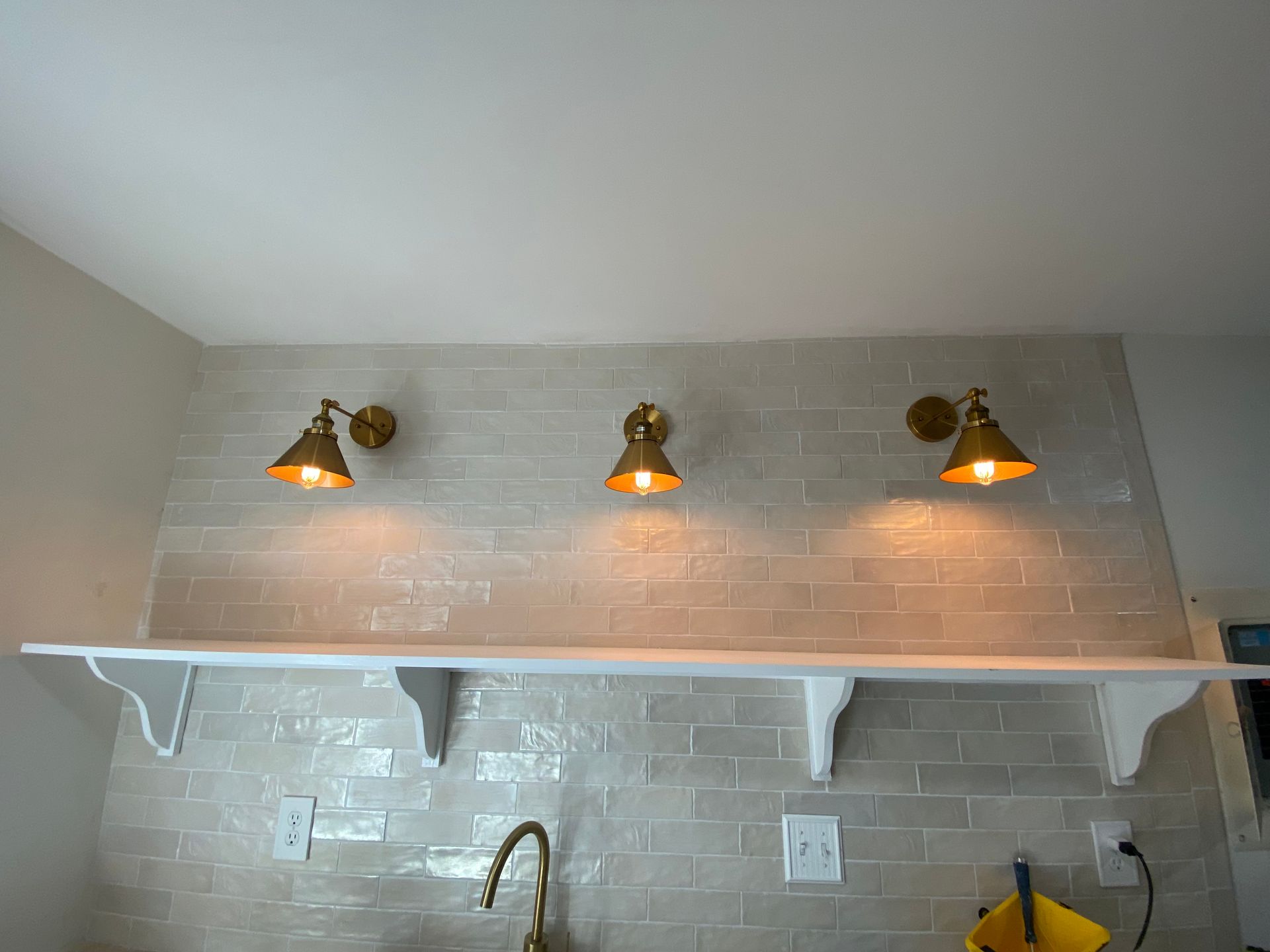 Bright modern white kitchen with subway tile backsplash, stainless steel appliances, and dark flooring