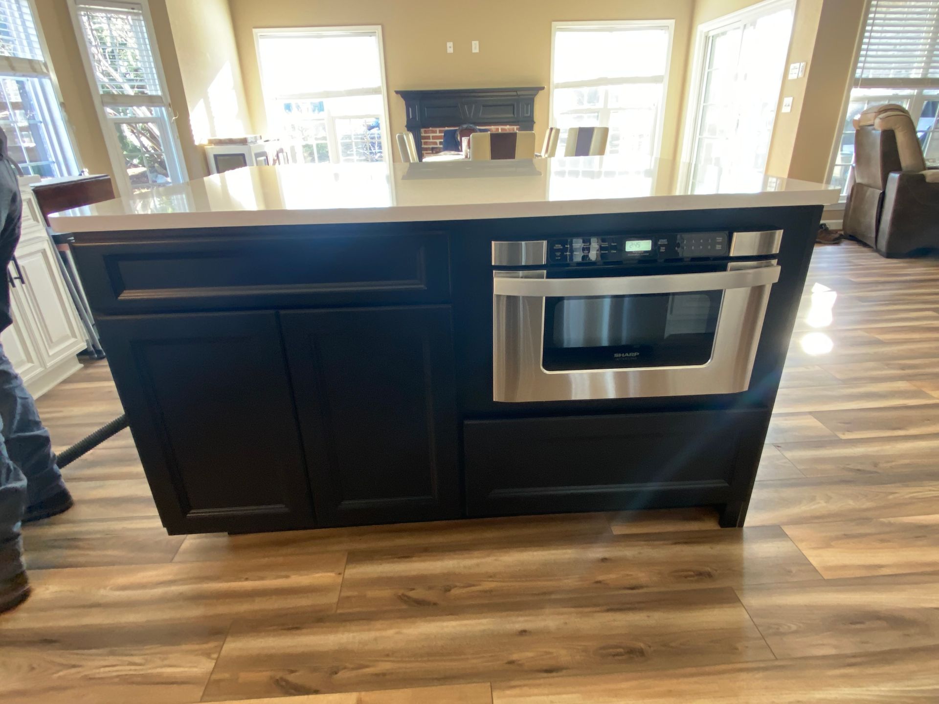 Bright modern white kitchen with subway tile backsplash, stainless steel appliances, and dark flooring