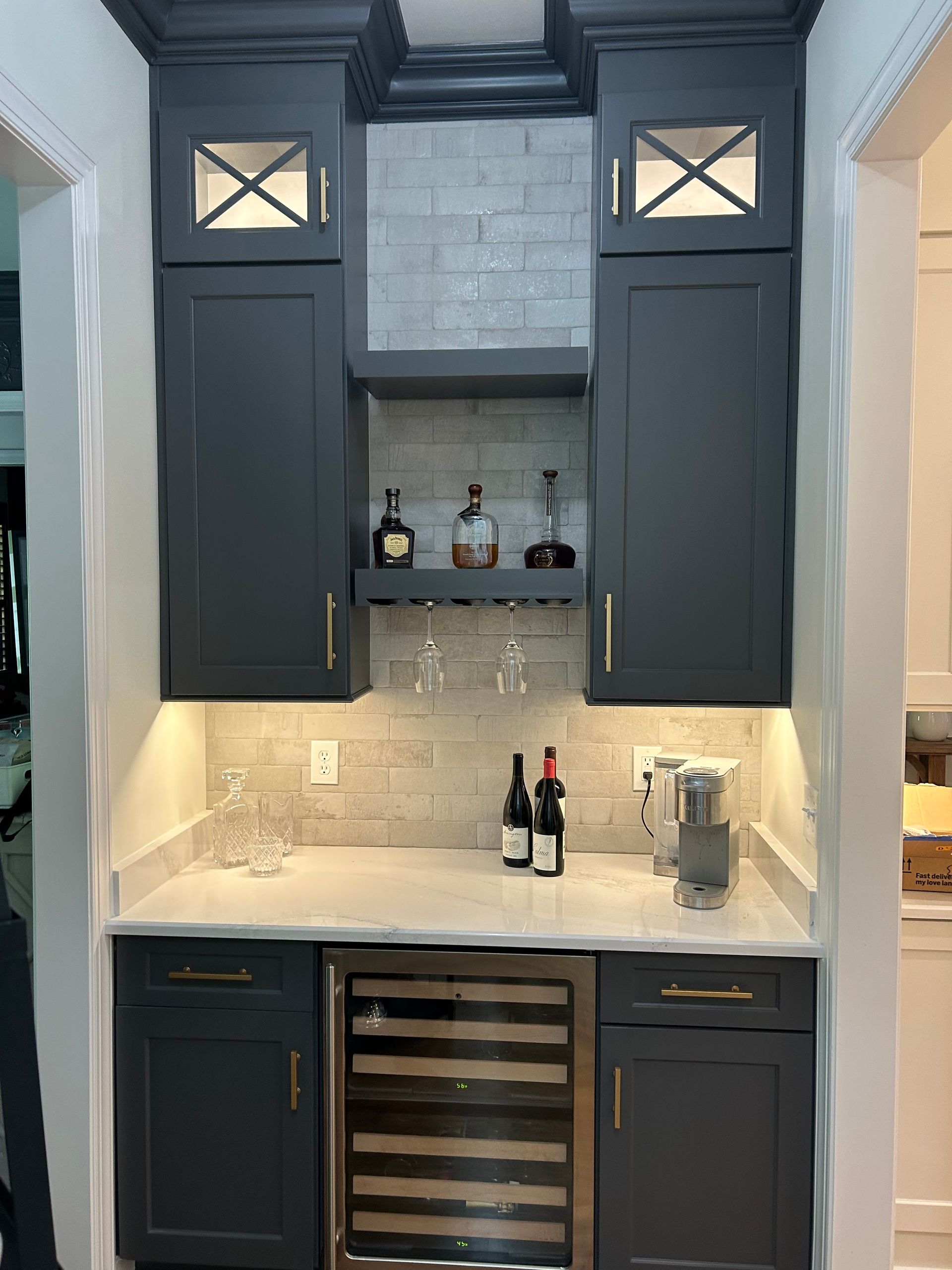Modern kitchen with gray cabinets, marble island, pendant lights, and stainless steel appliances