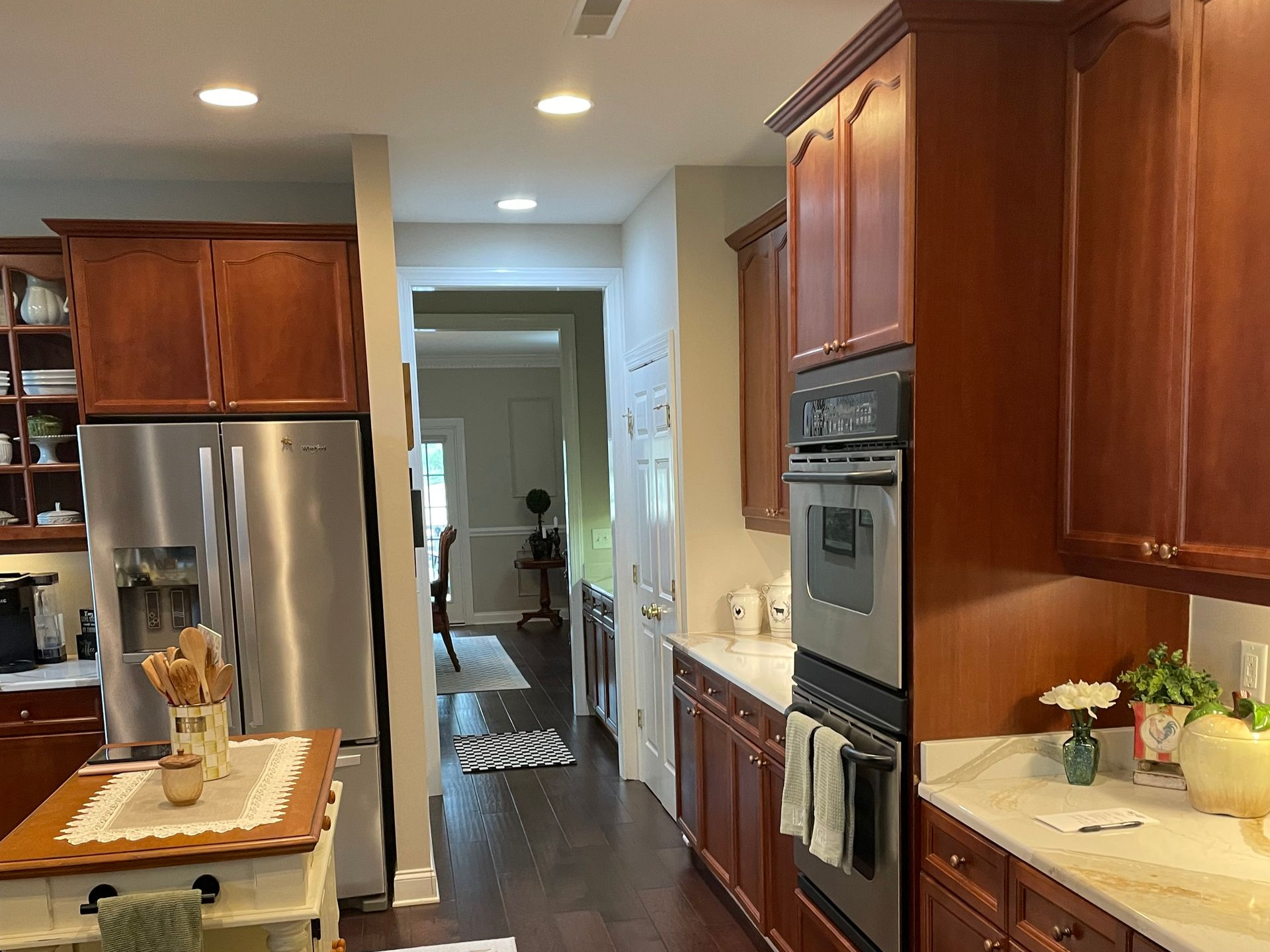Modern kitchen with wood cabinets, stainless steel appliances, black tile backsplash, and light tile floor
