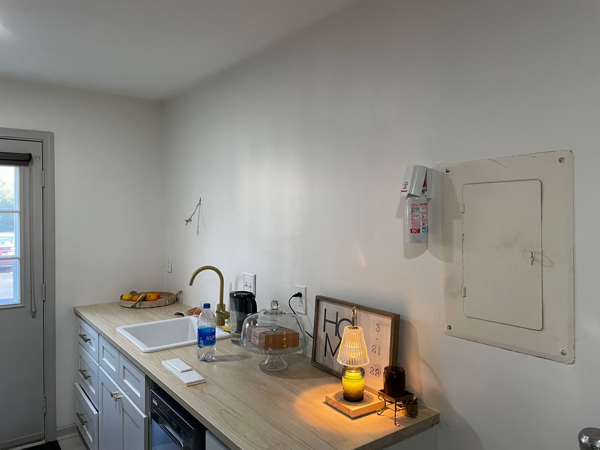Modern kitchen with wood cabinets, stainless steel appliances, black tile backsplash, and light tile floor