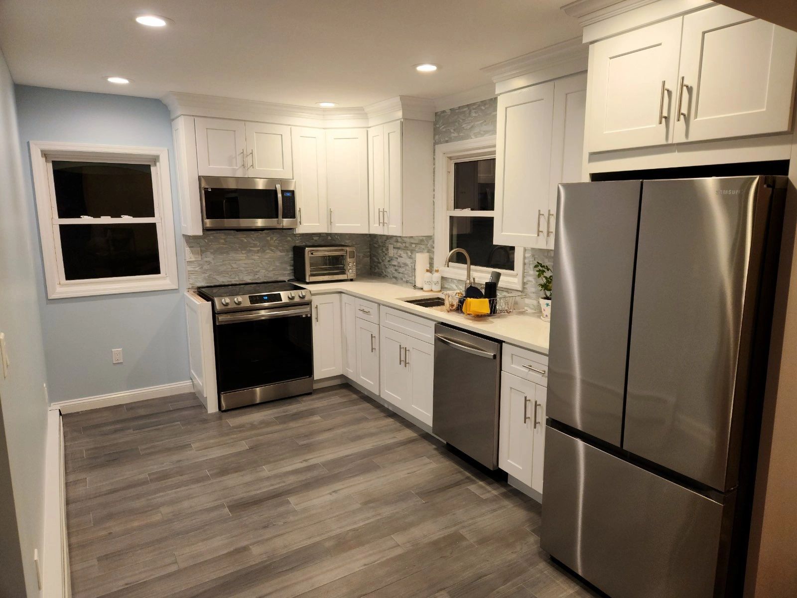 A kitchen with stainless steel appliances and white cabinets