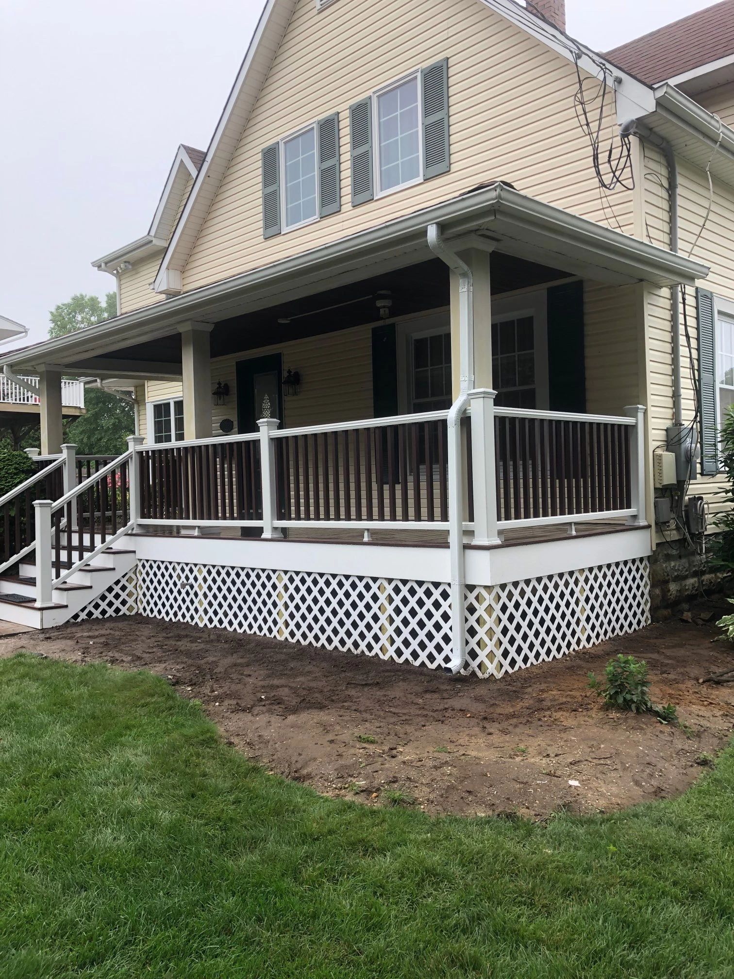 A house with a porch and stairs in front of it.