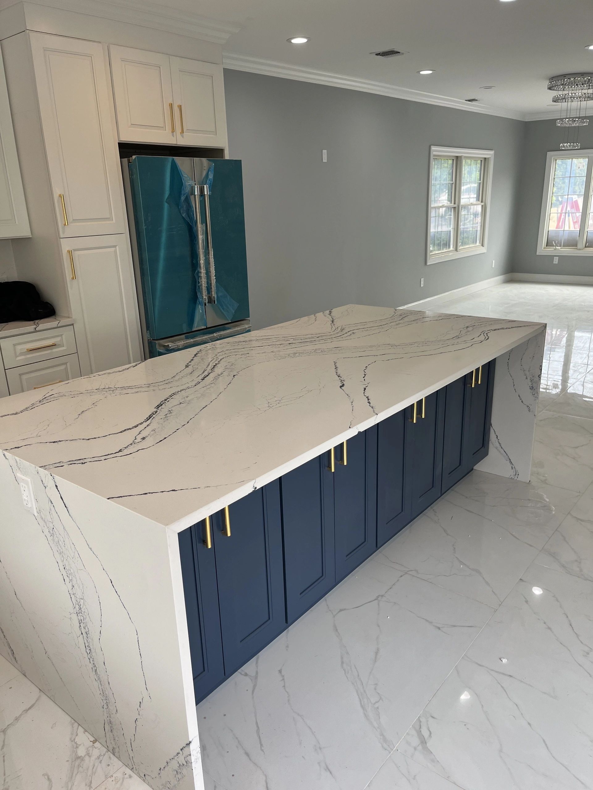 A kitchen with a large island and blue cabinets