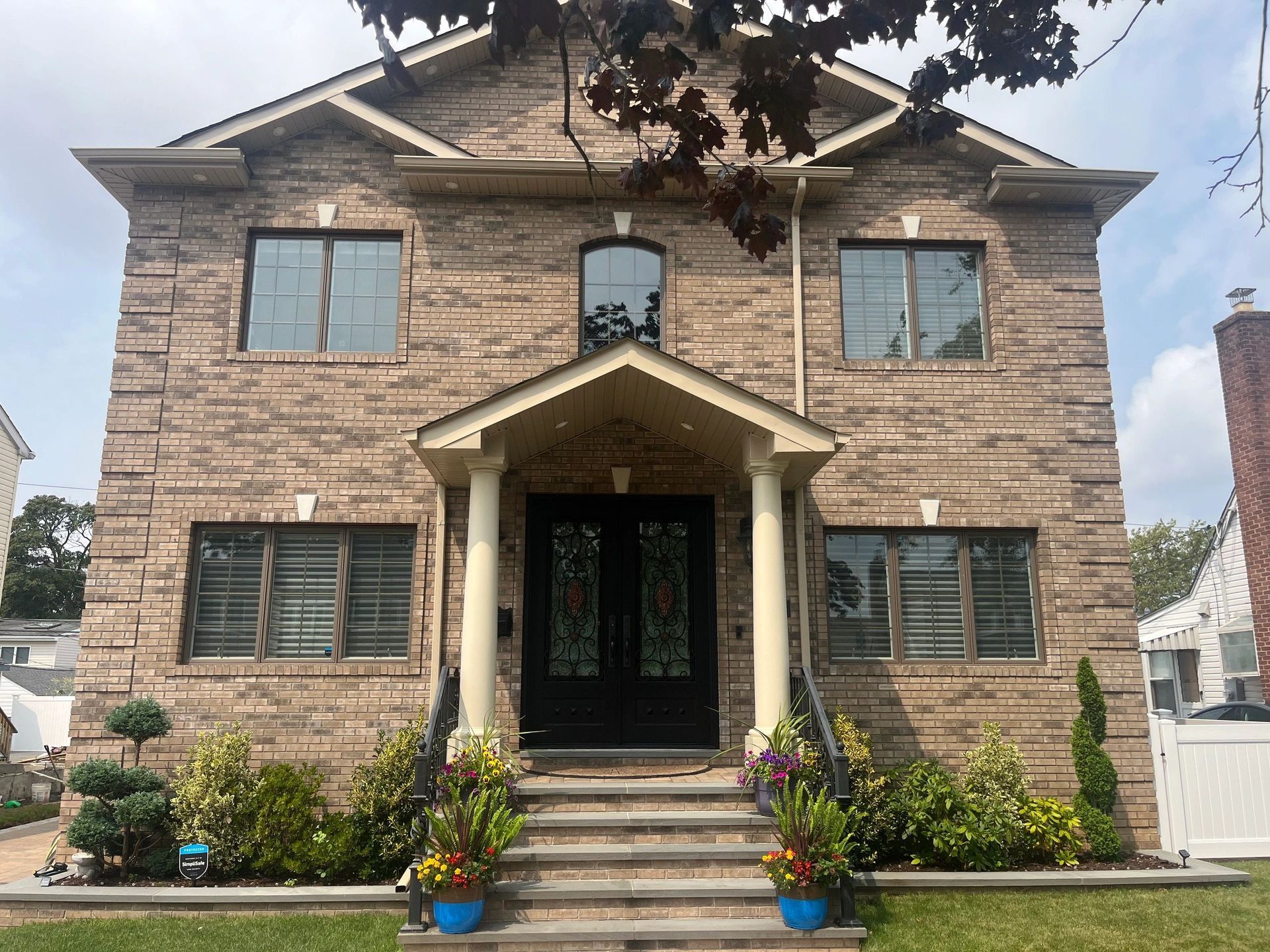 A large brick house with a porch and stairs