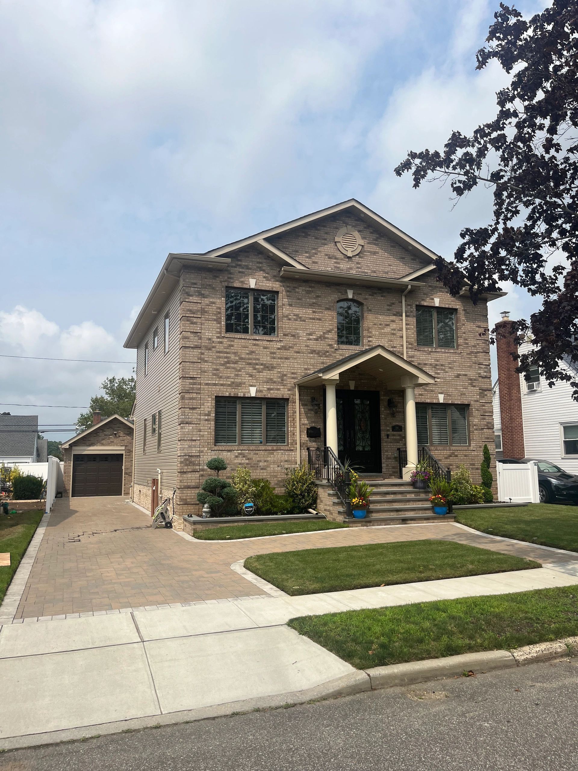 A large brick house with a large driveway and a garage.