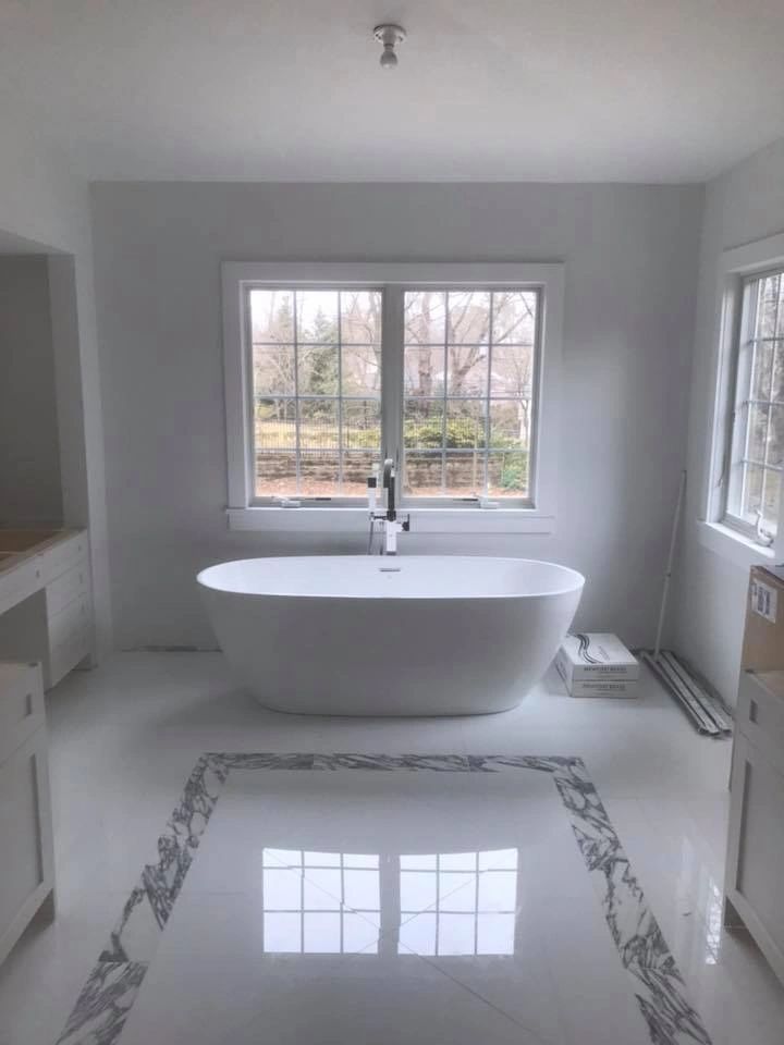 A bathroom with a bathtub and a window.