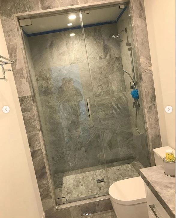A bathroom with a walk in shower and a toilet.