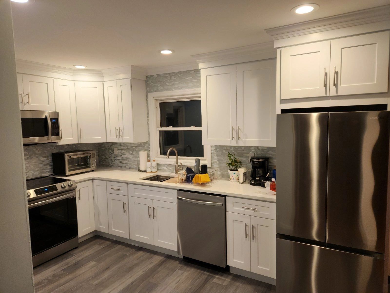A kitchen with white cabinets and stainless steel appliances.