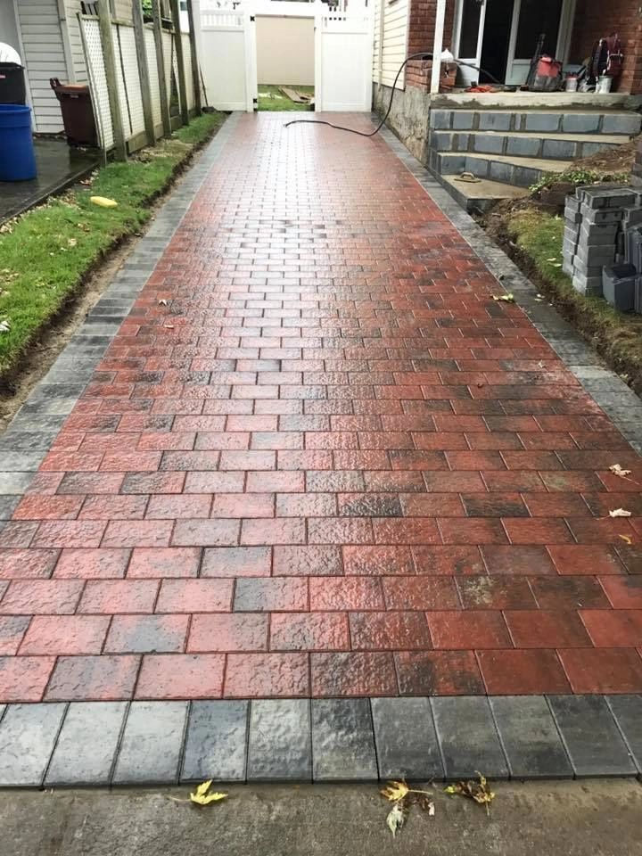 A brick walkway is being built in front of a house.