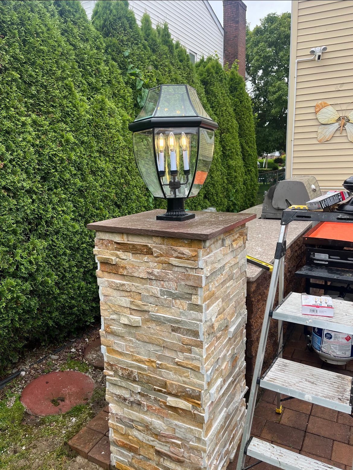 A stone pillar with a lamp on top of it.