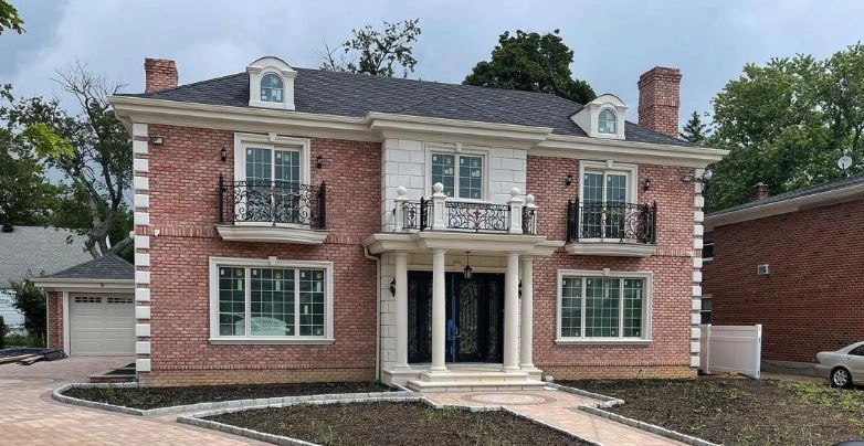 A large brick house with a car parked in front of it.
