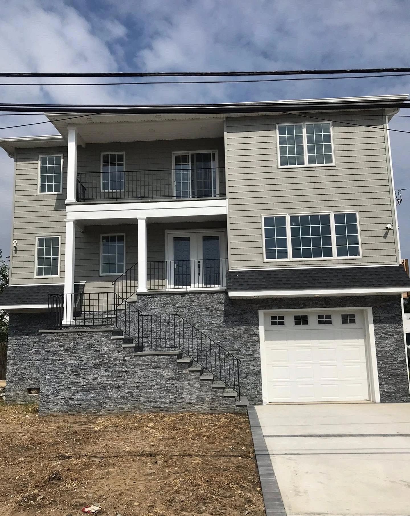 A large house with a white garage door and stairs