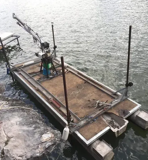 A boat with a crane attached to it is in the water
