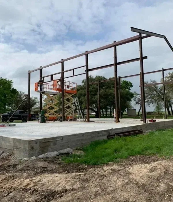 A large metal structure is being built in a field.