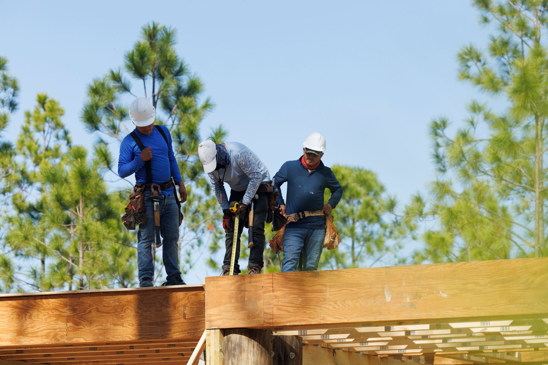 Workers working on the roof of a house.