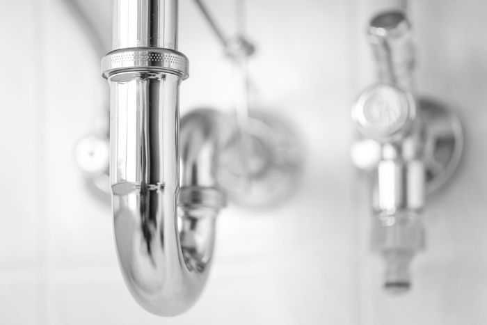 A close up of a plumbing pipe in a bathroom.