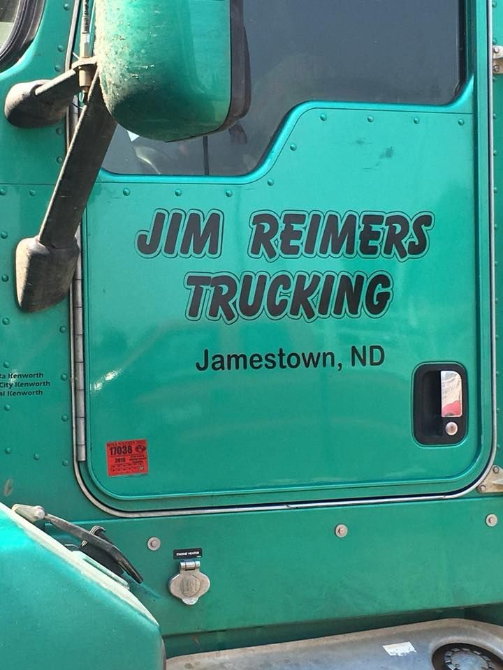 A green truck with the name jim reimers trucking on the door