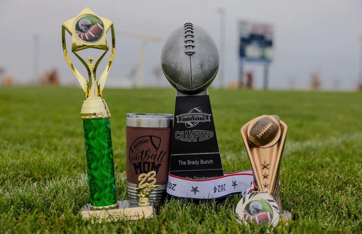 A group of trophies sitting on top of a football field.