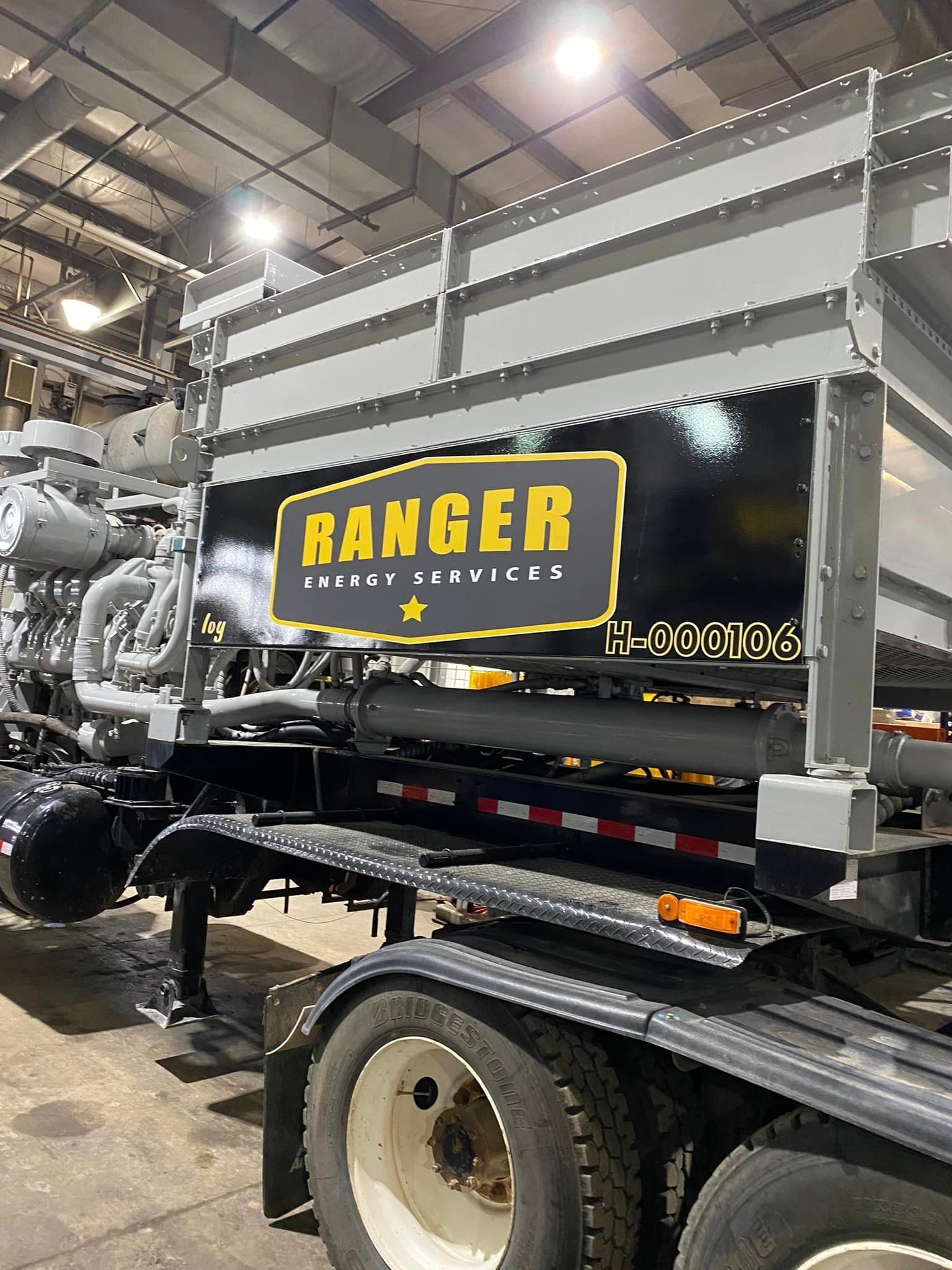 A truck is parked in a garage with a sign on the side that says ranger.