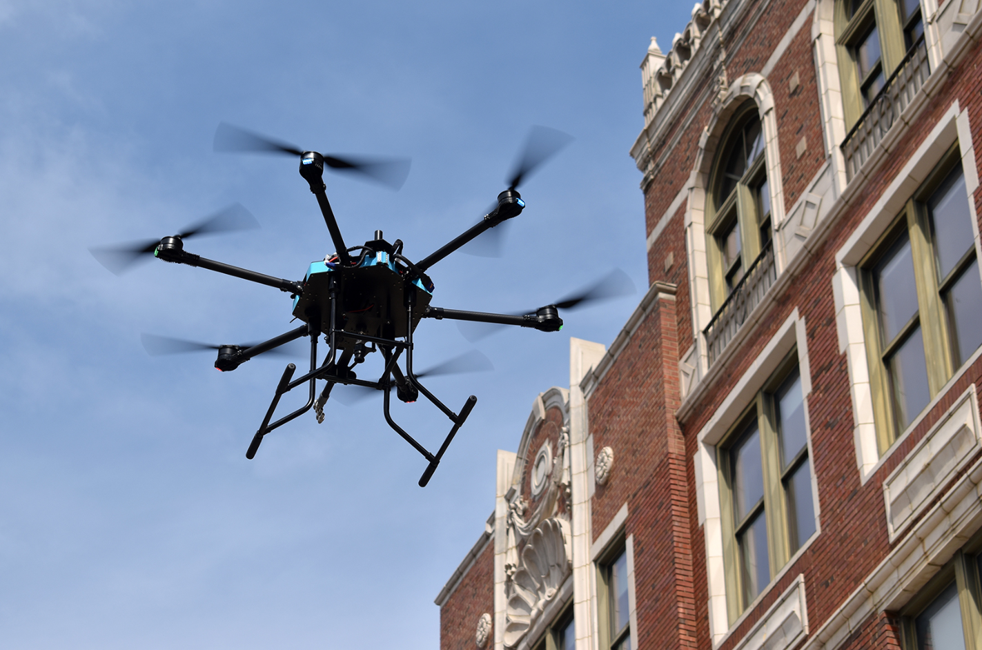 A drone is flying over a brick building