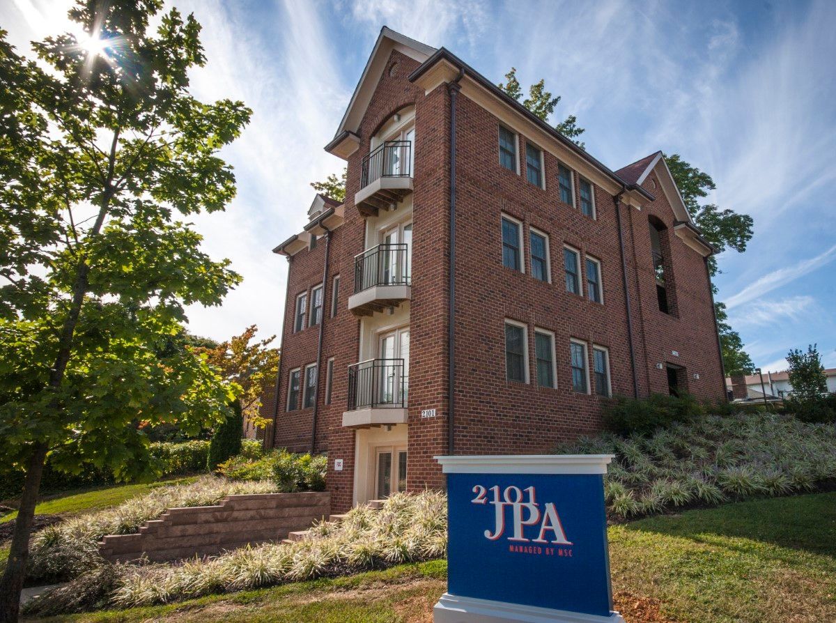 A large brick building with a sign in front of it that says jpa.