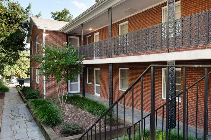 A brick apartment building with stairs leading up to the second floor.