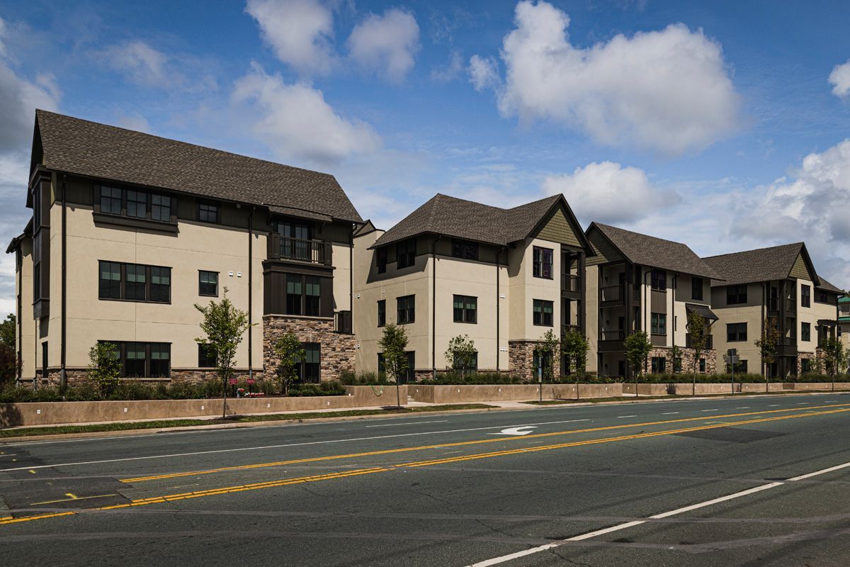 A large apartment building is sitting on the side of a road.