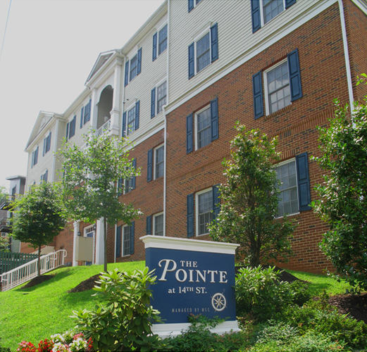 A large brick building with a blue sign that says the pointe.