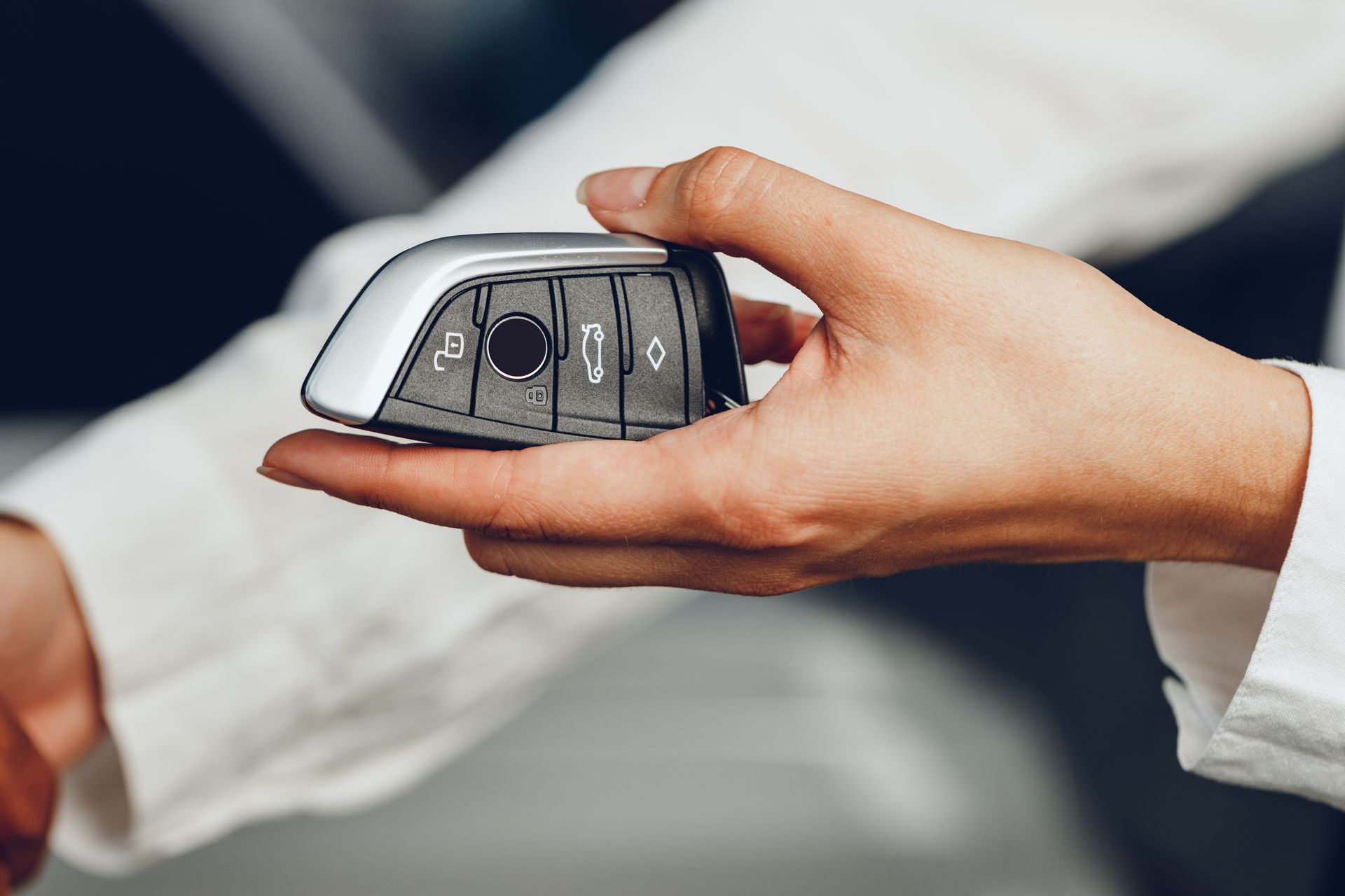 A person is holding a car key in their hand.