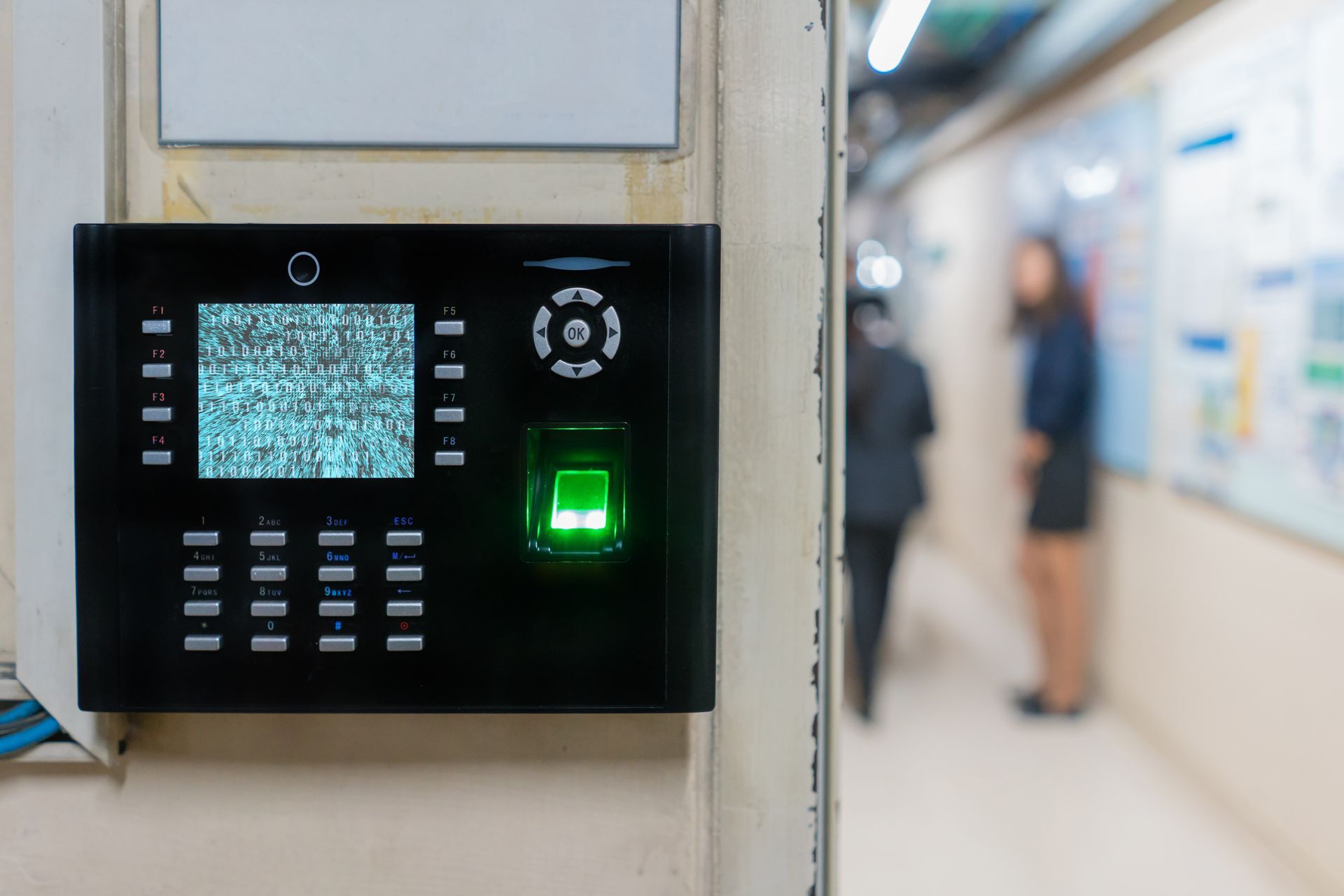 A fingerprint scanner is hanging on a wall in a hallway.