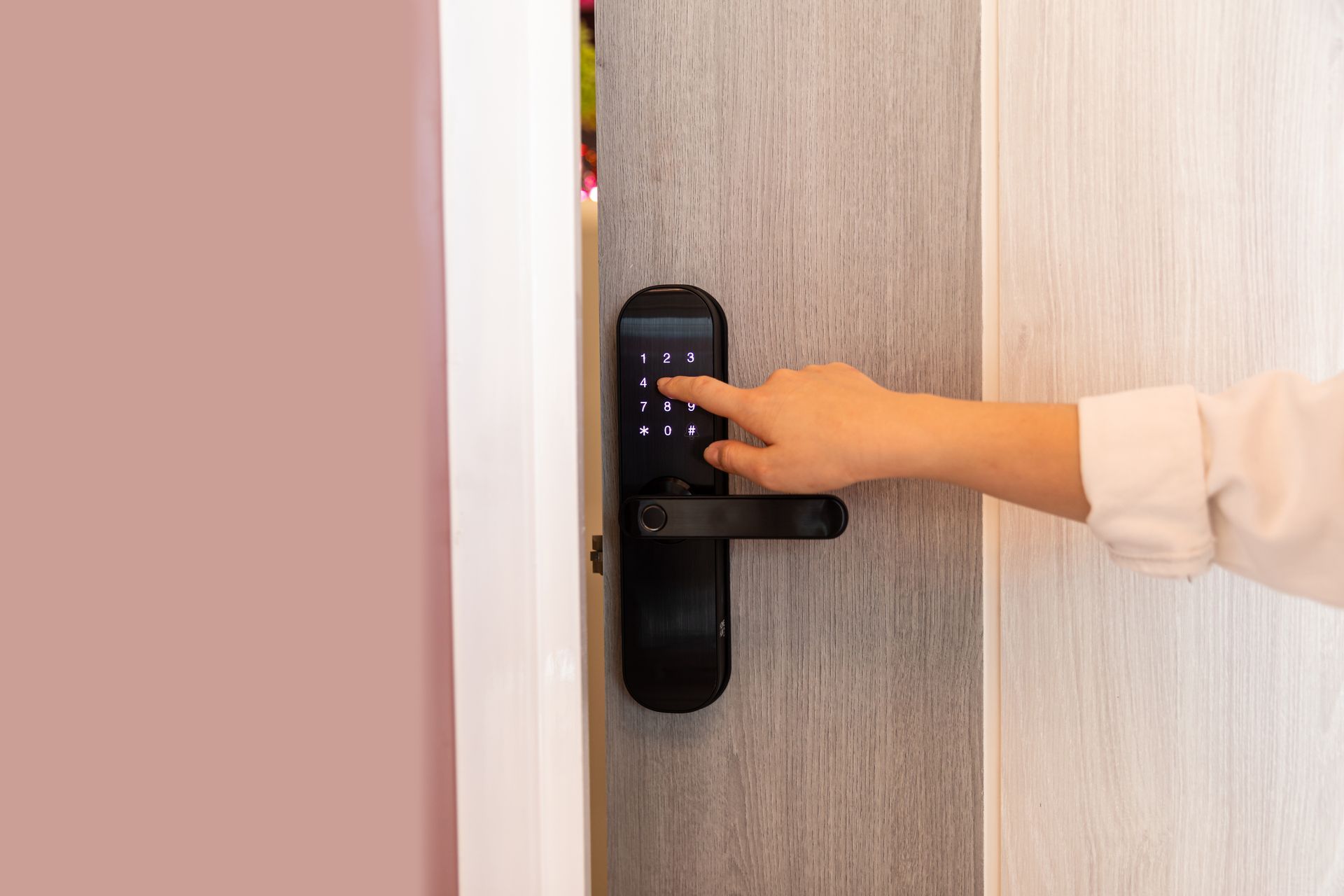 A person is pressing a button on a door lock.