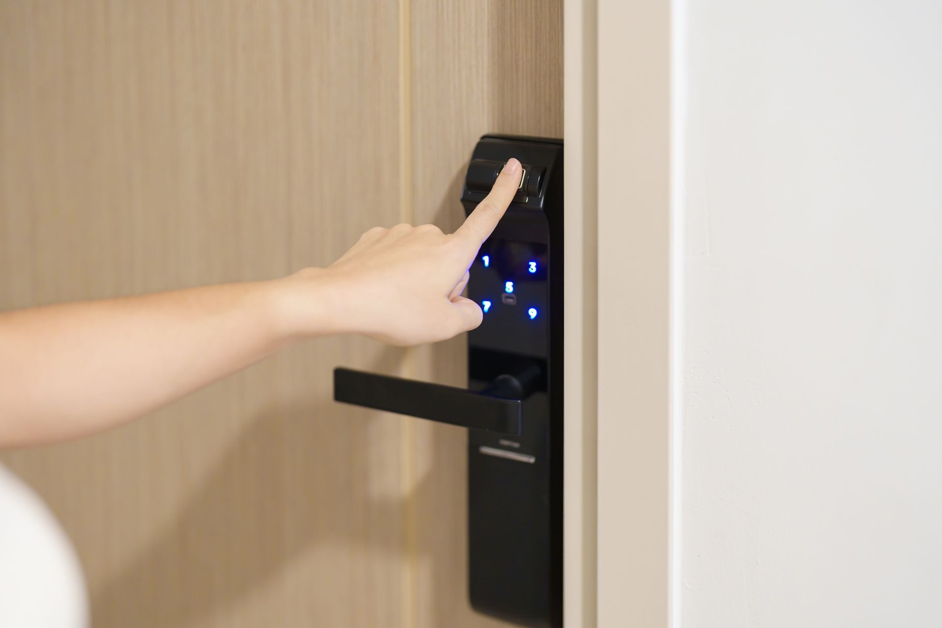 A person is pressing a button on a door lock.