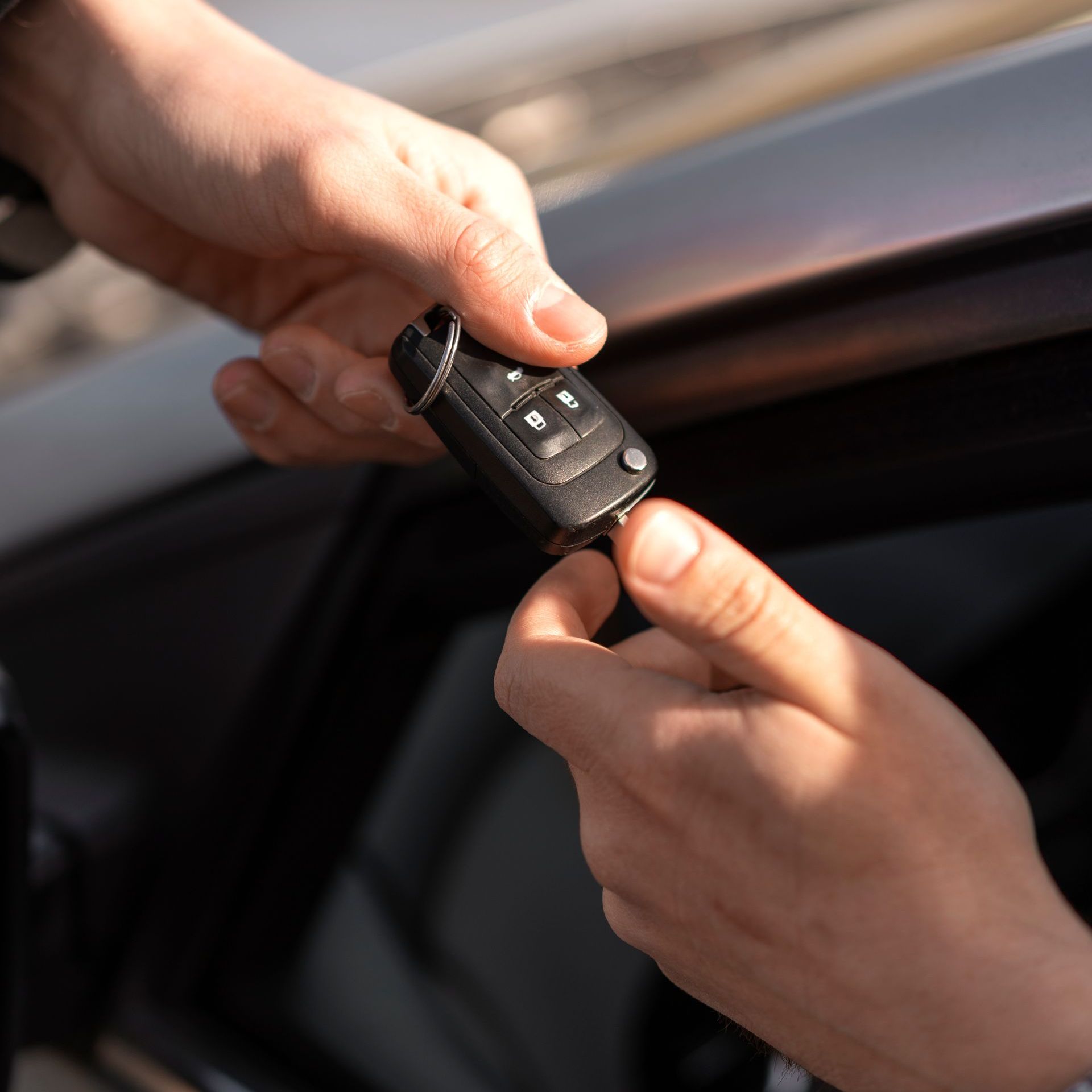 A person is handing a car key to another person
