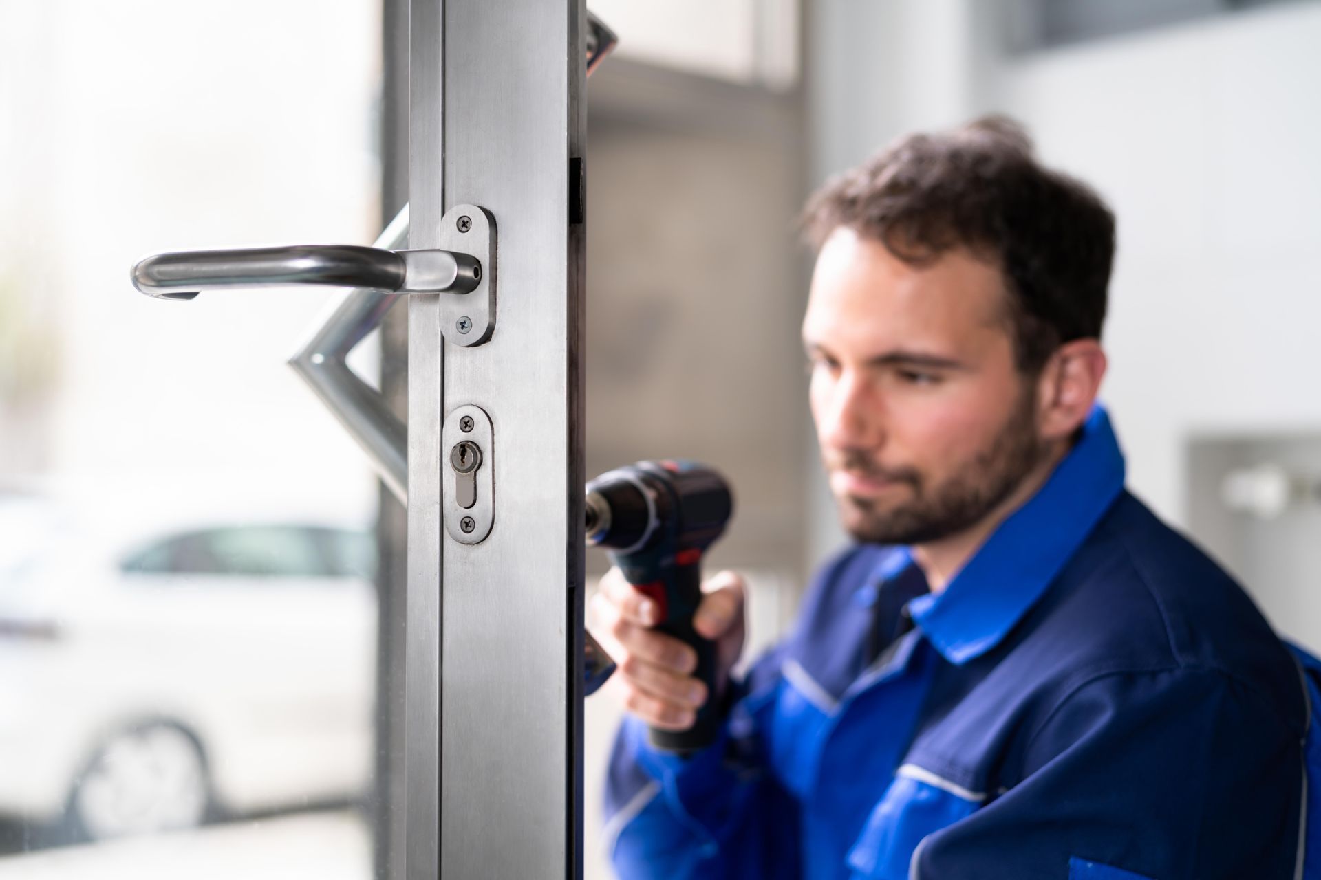 A man is fixing a door with a drill.