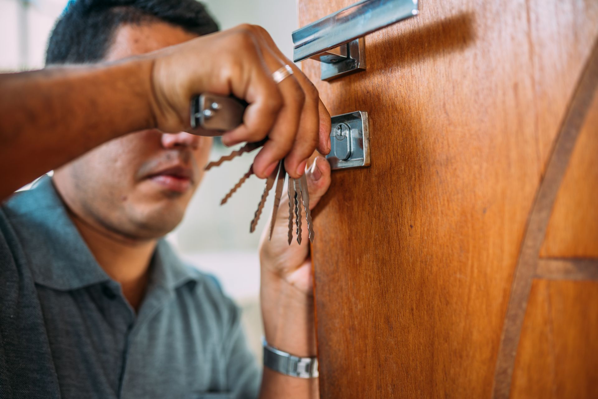 A man is holding a bunch of keys in a door lock.