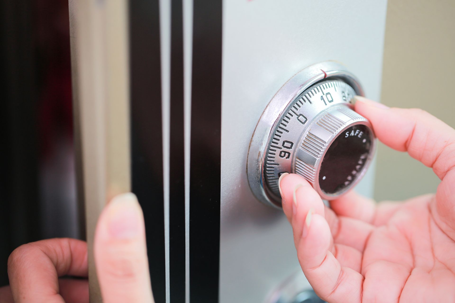 A person is opening a safe with their hand.