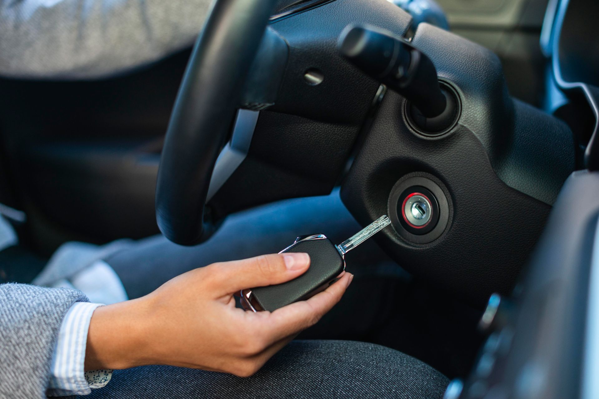 A person is holding a car key in their hand in a car.