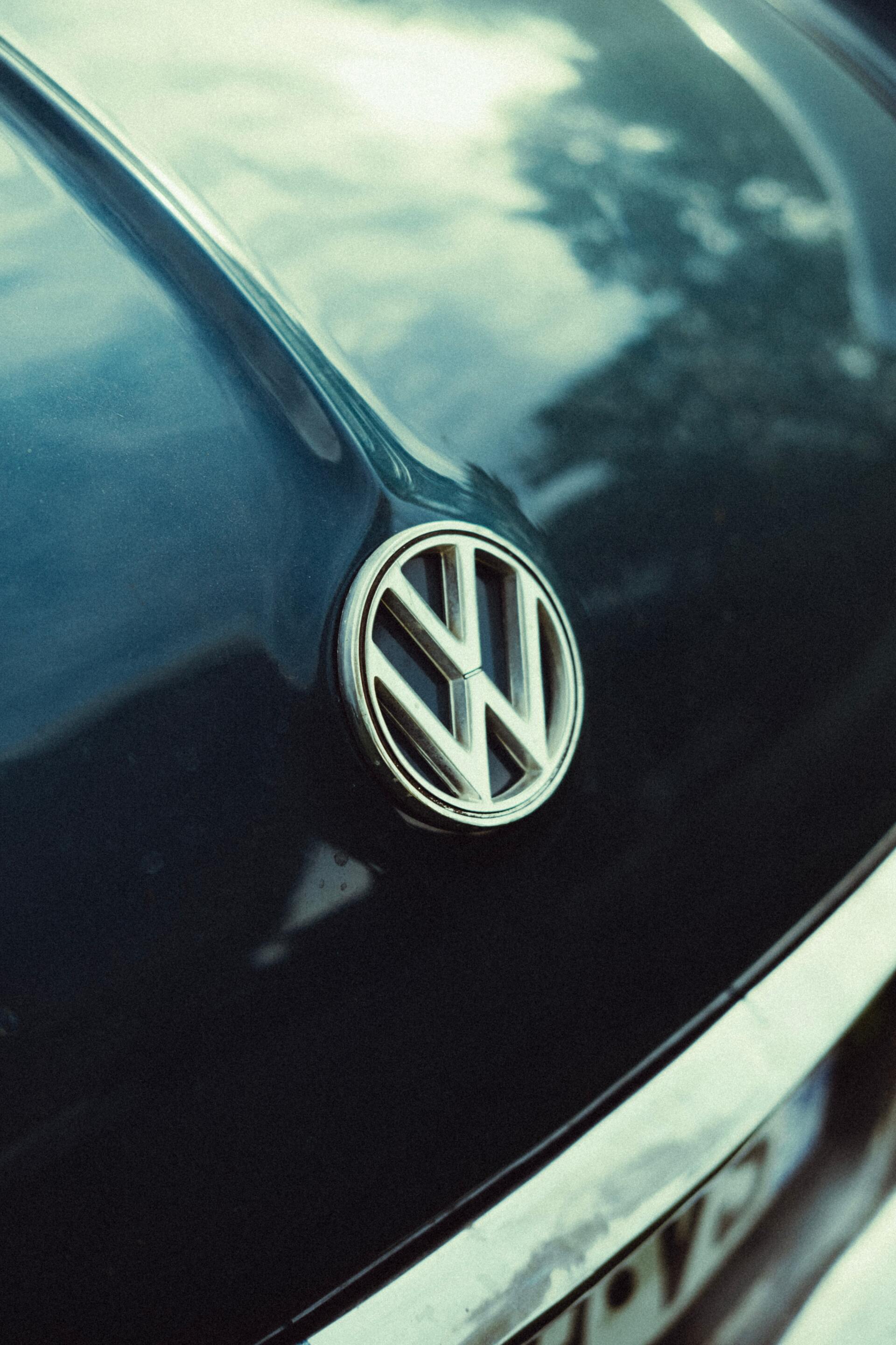 A close up of a volkswagen logo on the back of a car