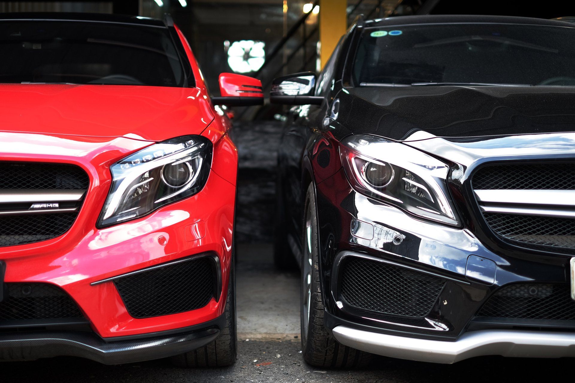 Two mercedes benz cars are parked next to each other in a garage.
