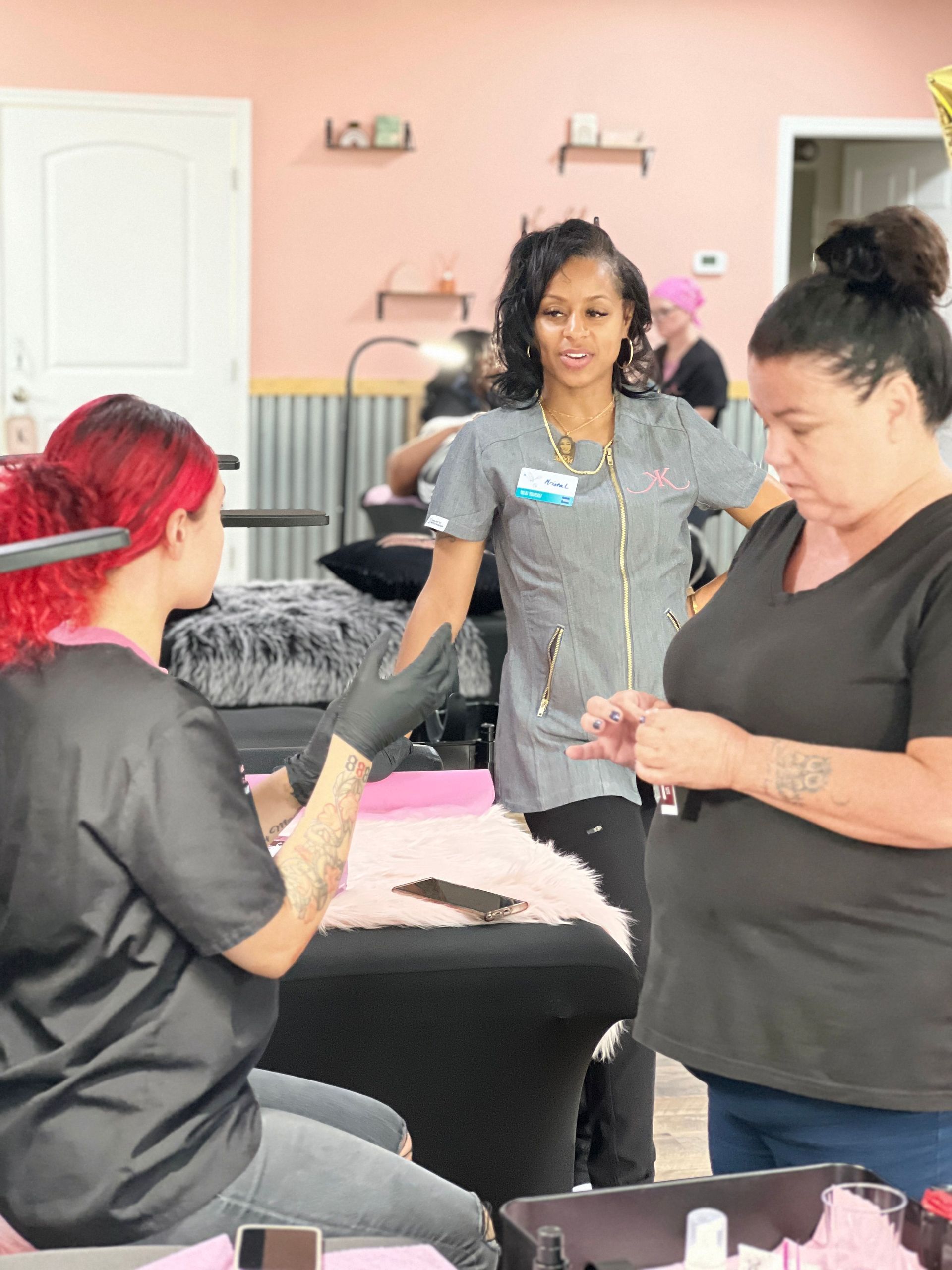 A group of women are standing around a table in a salon.