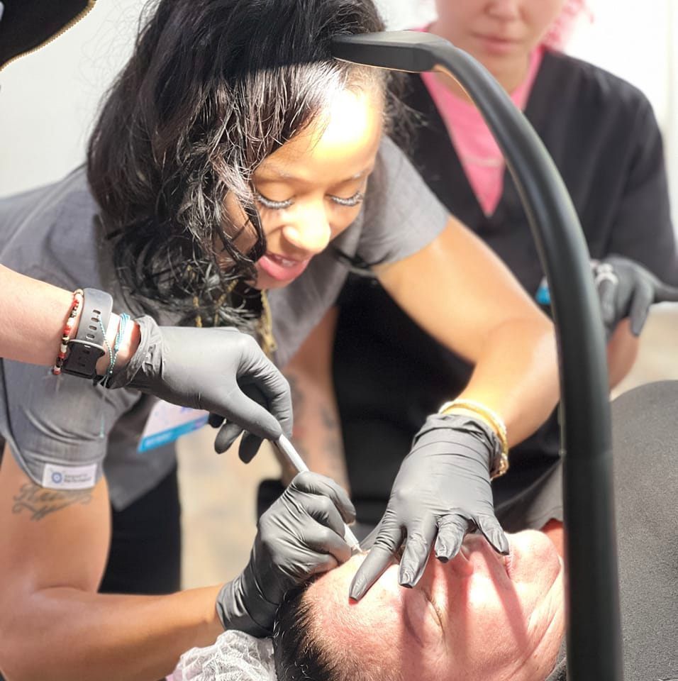 A woman wearing black gloves is working on a man