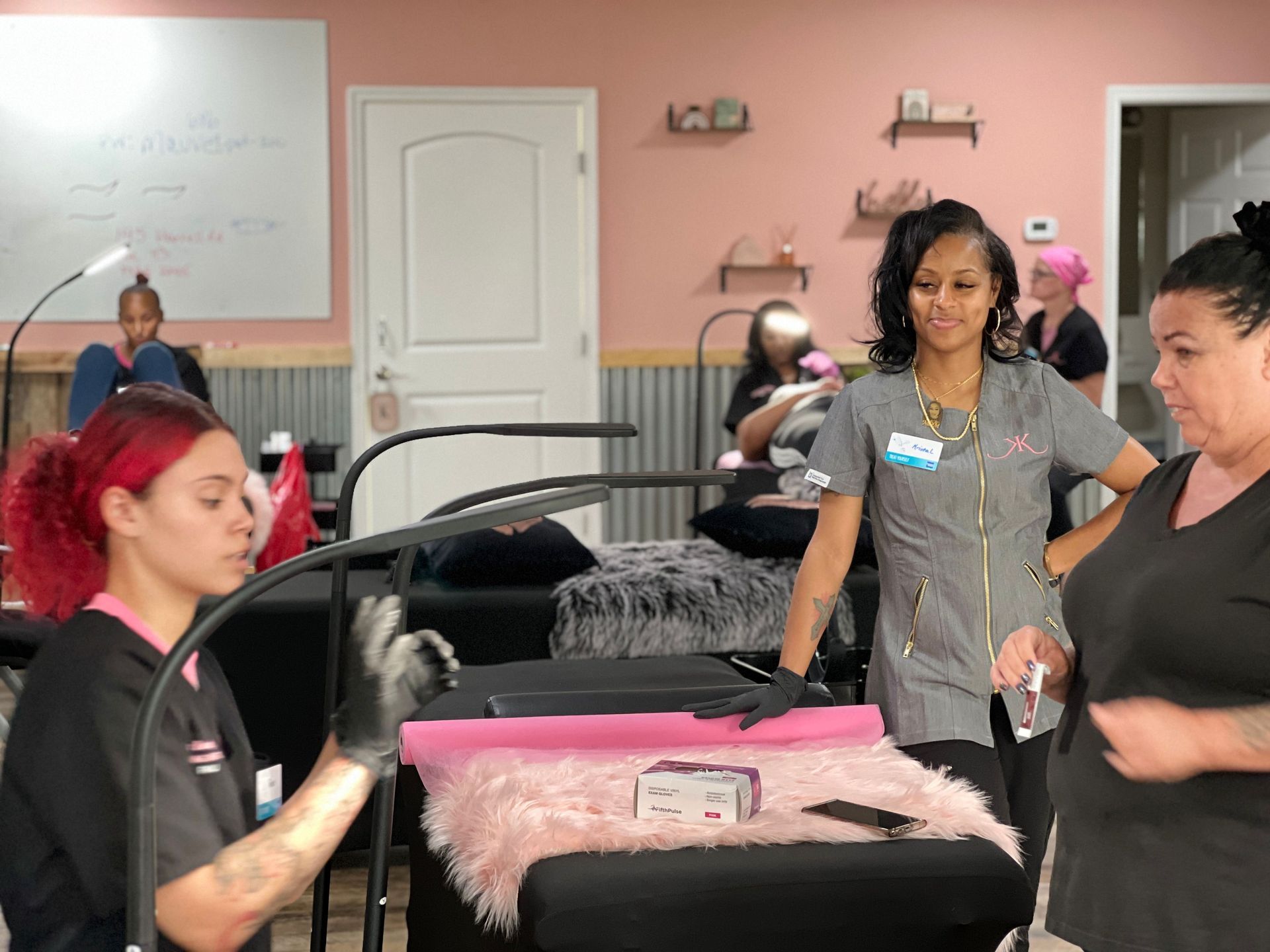 A group of women are standing around a table in a salon.