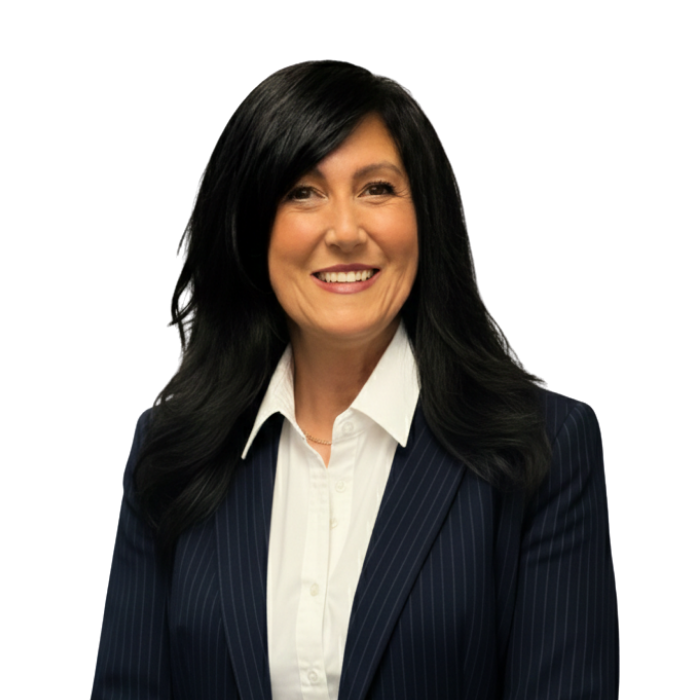 Bald man in glasses, navy suit, blue tie, white pocket square, smiling, looking at camera.